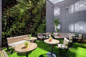 a patio with tables and chairs and plants at Hilton Garden Inn Budapest City Centre in Budapest