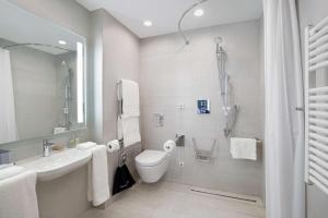 a bathroom with a toilet and a sink and a shower at Hilton Garden Inn Budapest City Centre in Budapest