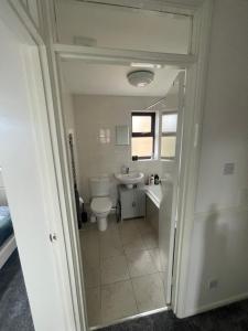 La salle de bains est pourvue de toilettes et d'un lavabo. dans l'établissement Home away from home, à Peterborough