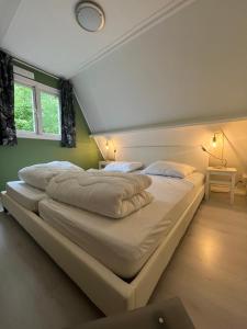 a large bed in a room with two pillows at Chalet 177 Durbuy in Durbuy