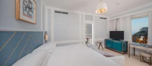 a bedroom with a white bed and a television at Hilton Imperial Dubrovnik in Dubrovnik