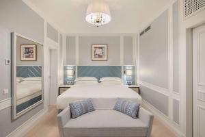 a bedroom with a bed and a chair in it at Hilton Imperial Dubrovnik in Dubrovnik
