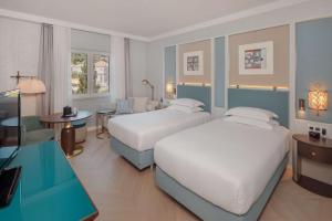 a hotel room with two beds and a table at Hilton Imperial Dubrovnik in Dubrovnik