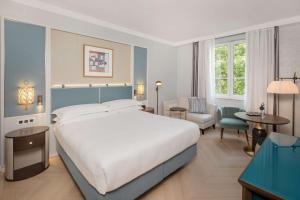 a bedroom with a large bed and a living room at Hilton Imperial Dubrovnik in Dubrovnik