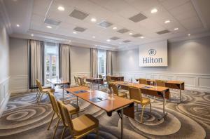 a restaurant with wooden tables and chairs in a room at Hilton Imperial Dubrovnik in Dubrovnik
