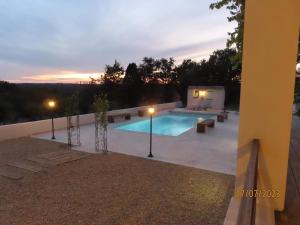 una piscina con panchine e un tramonto sullo sfondo di Charmante maison avec piscine ad Artignosc-sur-Verdon
