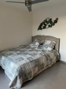 una camera da letto con un letto con una coperta e cuscini di Charmante maison avec piscine ad Artignosc-sur-Verdon