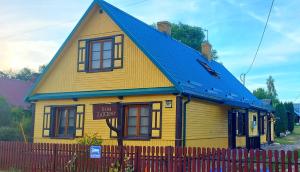 a small yellow house with a blue roof at Dom Zajezdny in Białowieża