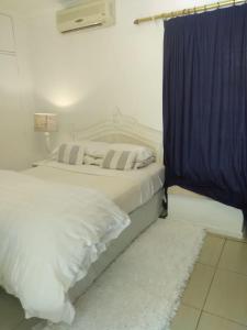1 dormitorio con 1 cama con cortina azul en Amethyst Suites (Part of Emerald Guest House), en Springs