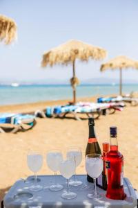 a table with three bottles and glasses on the beach at Nisaki Mathraki B&B in Corfu