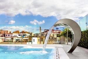 a pool with a water fountain in a city at Aleph Rome Hotel, Curio Collection By Hilton in Rome