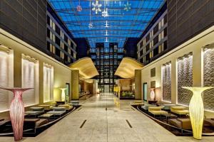 a lobby of a hotel with chairs and a ceiling at Hilton Frankfurt Airport in Frankfurt/Main