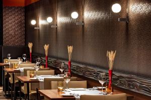 a dining room with tables and chairs with wine glasses at Hilton Frankfurt Airport in Frankfurt/Main