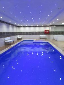 a large blue swimming pool in a large room at Grand Beyaz Saray Otel in Duzce