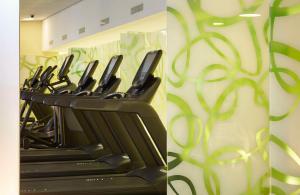 a row of exercise bikes in a gym with green swirls at Hilton Frankfurt Airport in Frankfurt/Main