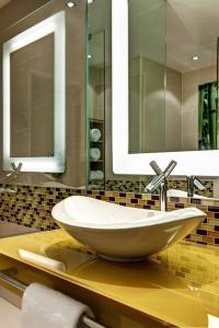 a bathroom with a sink and two mirrors at Hilton Frankfurt Airport in Frankfurt/Main