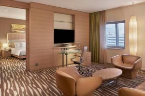 a hotel room with a bed and a living room at Hilton Frankfurt Airport in Frankfurt/Main