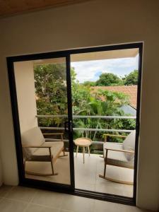 een kamer met een glazen schuifdeur met 2 stoelen en een tafel bij Apartamentos La Paz in Liberia