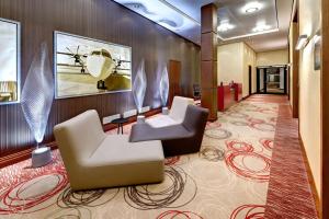 - un hall d'accueil avec 2 chaises et une table dans l'établissement Hilton Frankfurt Airport, à Francfort-sur-le-Main