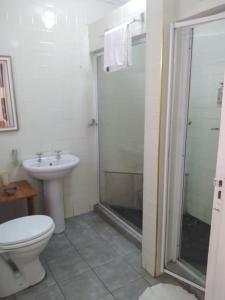 a bathroom with a shower and a toilet and a sink at Amethyst Suites (Part of Emerald Guest House) in Springs