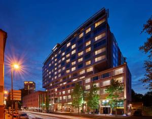 um edifício alto numa rua da cidade à noite em Hilton Frankfurt City Centre em Frankfurt