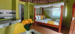 a bedroom with a bed with a vase of flowers on a table at Omnia Resort in Mtwapa