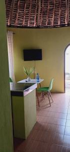a living room with a table and a green chair at Omnia Resort in Mtwapa
