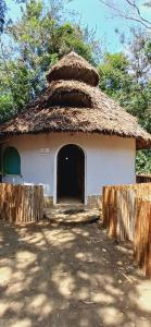 a small white building with a thatched roof at Omnia Resort in Mtwapa