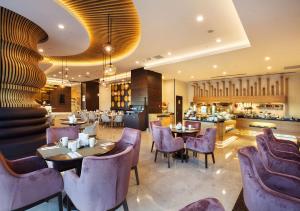 un restaurante con mesas y sillas de color púrpura y un bar en Hilton Garden Inn Isparta, en Isparta