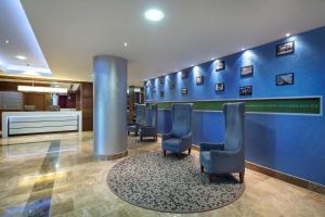ein Wartezimmer mit Stühlen und einer blauen Wand in der Unterkunft Hampton by Hilton Istanbul Kayasehir in Istanbul