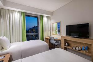 ein Hotelzimmer mit 2 Betten und einem Flachbild-TV in der Unterkunft Hampton by Hilton Istanbul Zeytinburnu in Istanbul