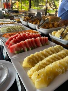 un buffet de diferentes tipos de comida en platos blancos en Flat Nannai Residence, en Porto de Galinhas