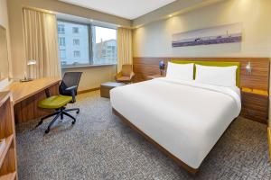 Pokój hotelowy z dużym łóżkiem i biurkiem w obiekcie Hampton by Hilton Istanbul Kayasehir w Stambule