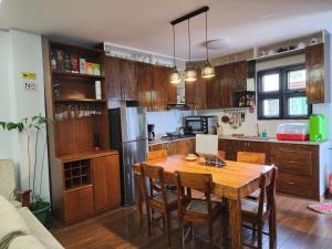 a kitchen with a wooden table and a kitchen with a refrigerator at Lorenzo's Homestay in Basco