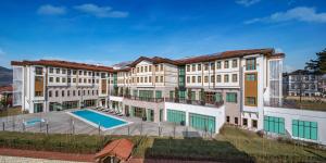 - un grand bâtiment avec une piscine en face dans l'établissement Hilton Garden Inn Safranbolu, à Safranbolu