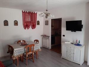 a dining room with a table and chairs and a television at House Vittone Venaria Reale in Venaria Reale