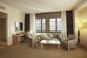 a living room with a couch and chairs and a desk at Hilton Milan in Milan