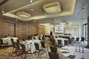 a banquet hall with tables and chairs and a podium at Hilton Milan in Milan