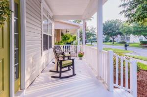 a porch with a chair and a table on a house at Calypso Cottage in Bluffton