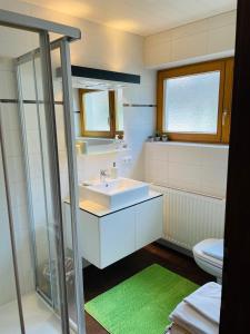 uma casa de banho com um lavatório e um WC em Appartement Anja em Fügen