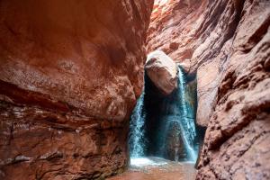 a waterfall in the middle of a canyon at Wolfe's Hotel Moab in Moab