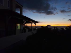 Creta Luxury Villas في مدينة هيراكيلون: غروب الشمس على منزل مع غروب الشمس في الخلفية