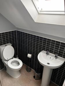 a bathroom with a toilet and a sink at VRLProperties. in Gloucester