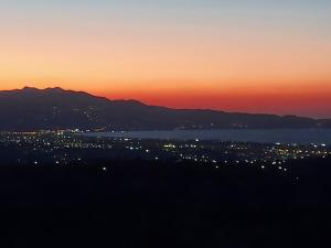 een zonsondergang boven een stad met een berg op de achtergrond bij Creta Luxury Villas in Heraklion
