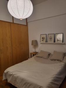 a bedroom with a large white bed with a chandelier at Apartamento Rosa Puerta del Sol (2) in Madrid