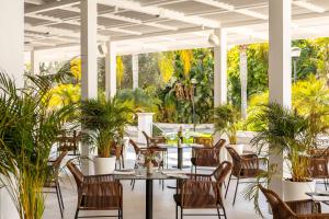 um restaurante com mesas, cadeiras e plantas em Hilton Nicosia em Nicósia