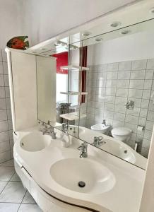 een witte badkamer met een wastafel en een spiegel bij Beautiful villa with garden in Milanówek in Milanówek