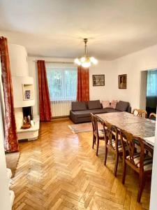 een woonkamer met een tafel en een bank bij Beautiful villa with garden in Milanówek in Milanówek