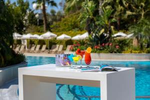 a white table with drinks on it next to a pool at Hilton Nicosia in Nicosia