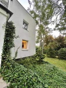 Una casa blanca con una ventana en el costado. en Beautiful villa with garden in Milanówek, en Milanówek